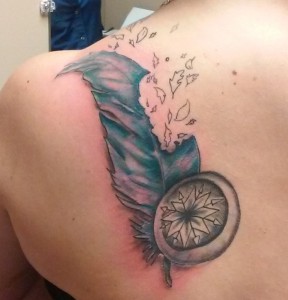 Feather and compass tattoo on shoulder, colored